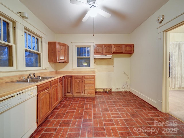 113 2nd St, Spencer, NC 28159 - kitchen featuring white dishwasher, a sink, under cabinet range hood, brick patterned floors, and light countertops