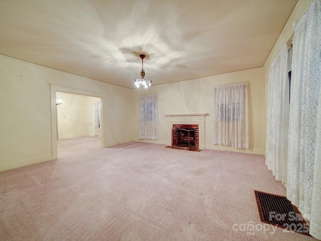 113 2nd St, Spencer, NC 28159 - unfurnished living room featuring carpet floors, a brick fireplace, baseboards, and a chandelier