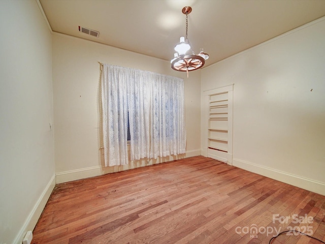 113 2nd St, Spencer, NC 28159 - spare room featuring a chandelier, light wood-style flooring, and baseboards