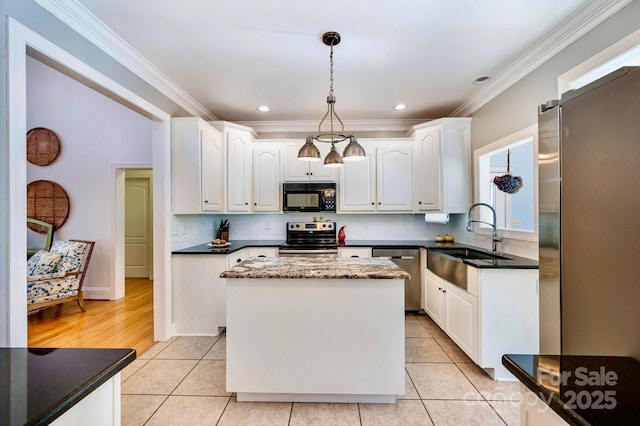 kitchen featuring sink, appliances with stainless steel finishes, white cabinetry, hanging light fixtures, and a center island