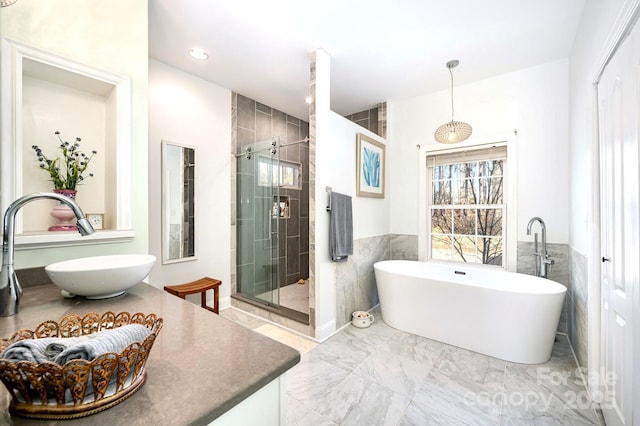 bathroom with vanity, separate shower and tub, and tile walls