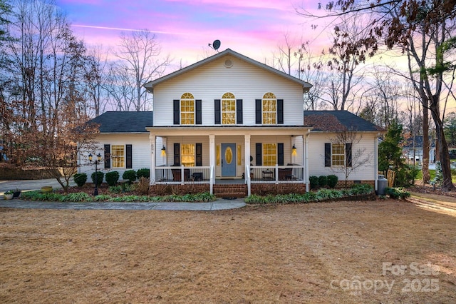 front of property featuring a yard and a porch