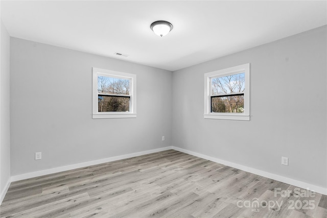 empty room featuring light hardwood / wood-style flooring and a wealth of natural light