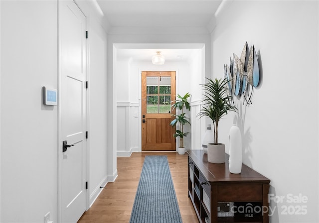 interior space with ornamental molding and light hardwood / wood-style floors