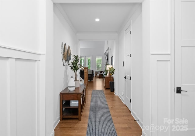 hall featuring ornamental molding and light hardwood / wood-style floors