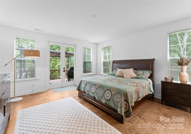 bedroom with hardwood / wood-style flooring, french doors, and access to outside