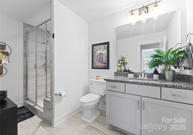 bathroom featuring vanity, a shower with shower door, and toilet