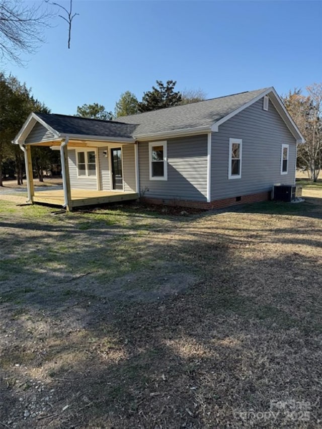 view of front of property featuring a front yard, central AC unit, and a porch