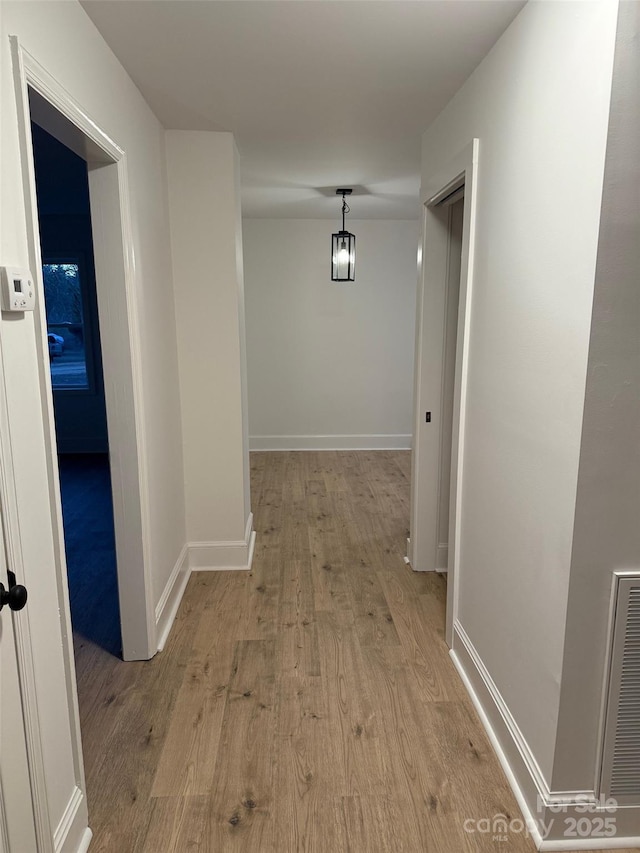 corridor with light hardwood / wood-style floors