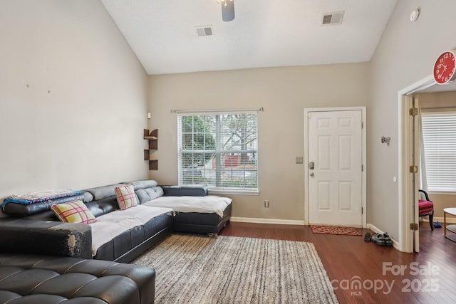 living room featuring lofted ceiling and dark hardwood / wood-style flooring