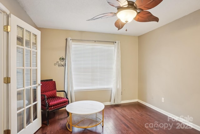 sitting room with ceiling fan, dark wood-type flooring, and a healthy amount of sunlight