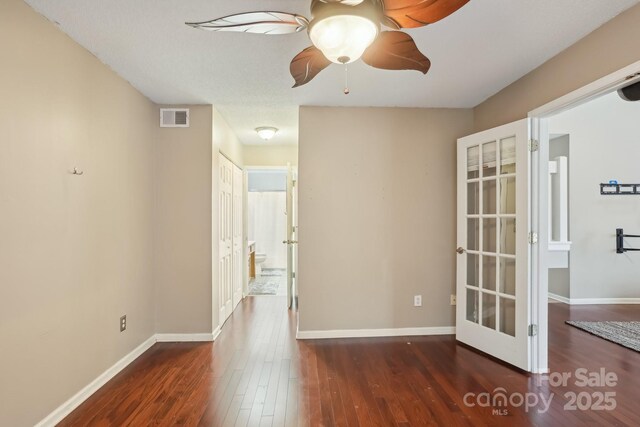 empty room with ceiling fan and dark hardwood / wood-style floors