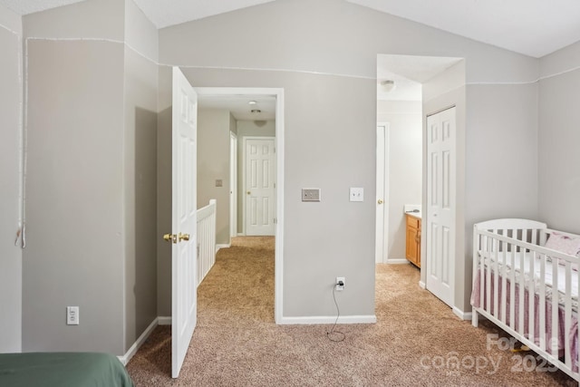 bedroom with a closet, lofted ceiling, and light carpet