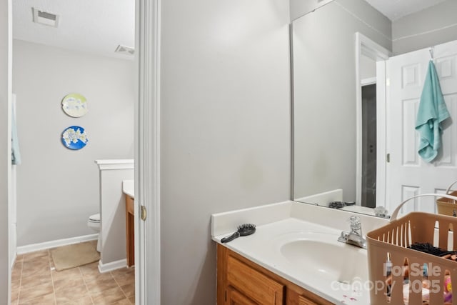 bathroom with tile patterned flooring, vanity, and toilet