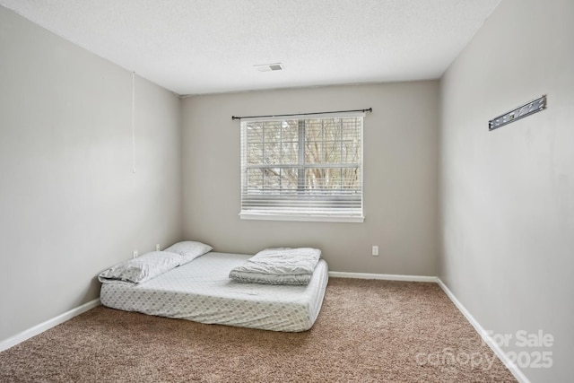 carpeted bedroom with a textured ceiling