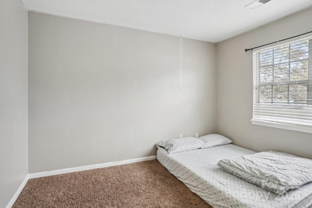 bedroom with carpet and a textured ceiling