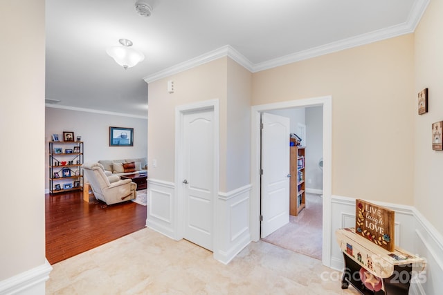 hallway with crown molding and light hardwood / wood-style flooring