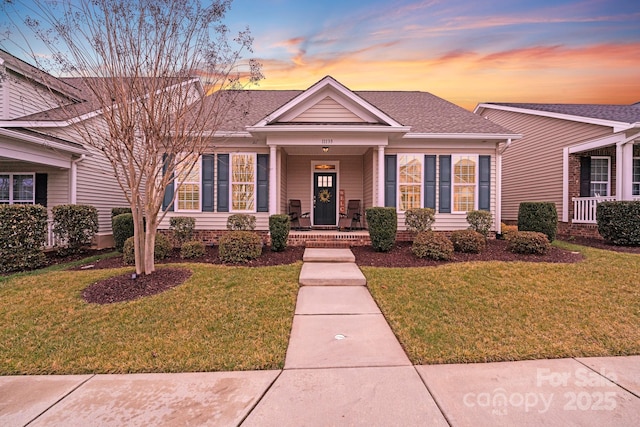 view of front of home with a lawn and a porch