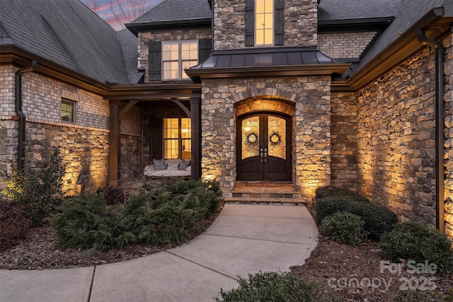 exterior entry at dusk featuring french doors