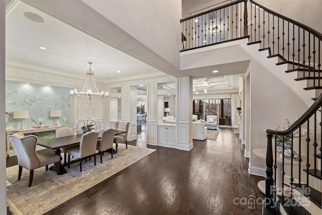 dining space featuring dark hardwood / wood-style flooring, crown molding, a chandelier, and a high ceiling