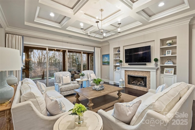 living room featuring a premium fireplace, coffered ceiling, a notable chandelier, and crown molding