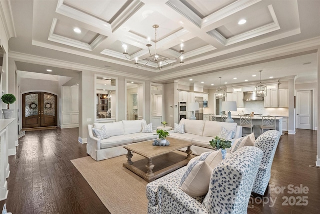 living room featuring ornamental molding, dark hardwood / wood-style flooring, coffered ceiling, and an inviting chandelier