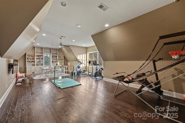 workout room with hardwood / wood-style floors, built in shelves, vaulted ceiling, and ceiling fan