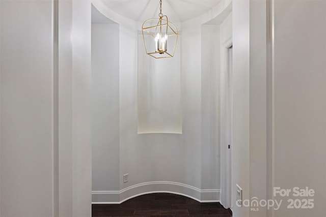 room details with baseboards, wood finished floors, and a notable chandelier