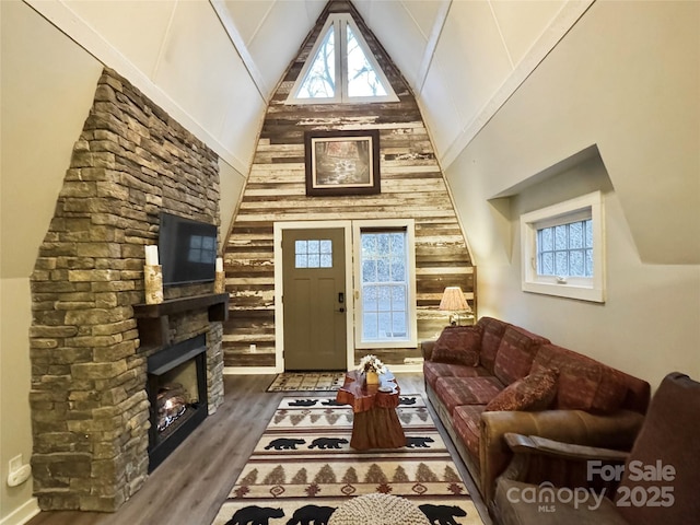 living room with dark hardwood / wood-style flooring, a fireplace, and high vaulted ceiling