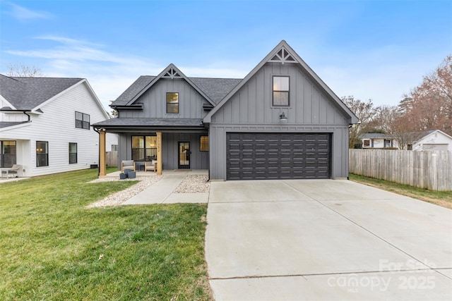 modern inspired farmhouse featuring a front lawn, a garage, and covered porch