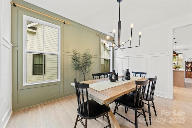 dining area featuring light hardwood / wood-style floors and a notable chandelier