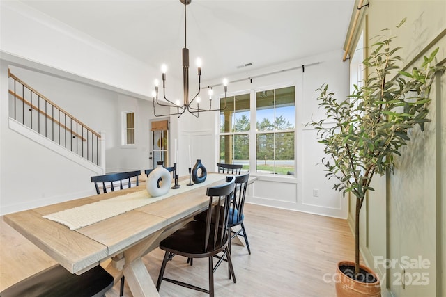 dining room with light hardwood / wood-style floors and a chandelier