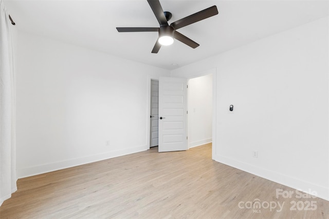 empty room with ceiling fan and light hardwood / wood-style flooring