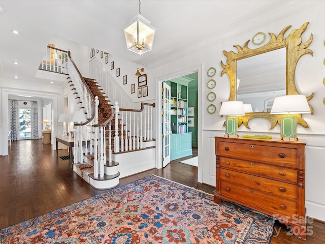 entryway featuring stairs, crown molding, an inviting chandelier, and hardwood / wood-style floors