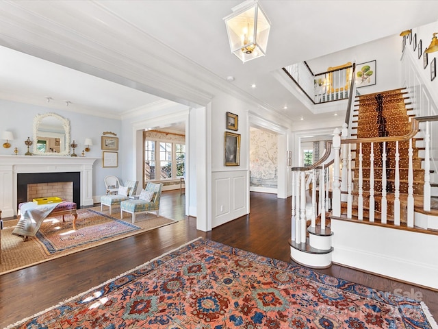entryway with a healthy amount of sunlight, ornamental molding, wood finished floors, and stairway