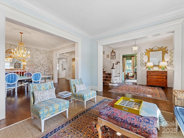 living room with ornamental molding, stairs, wood finished floors, and a chandelier