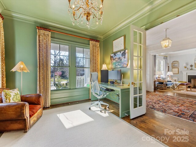 office space featuring ornamental molding, wood finished floors, and a notable chandelier