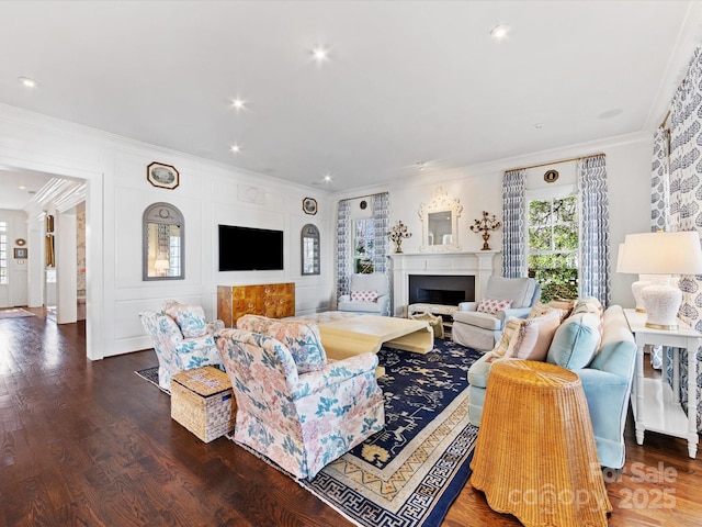 living area with crown molding, a fireplace, recessed lighting, and wood finished floors