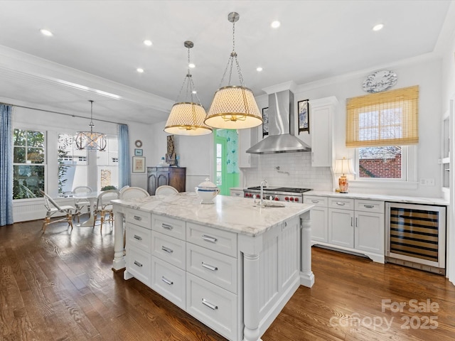 kitchen with dark wood-type flooring, wine cooler, white cabinets, and wall chimney range hood
