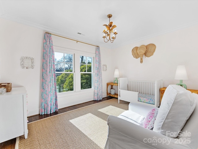 bedroom with baseboards, a notable chandelier, wood finished floors, and visible vents