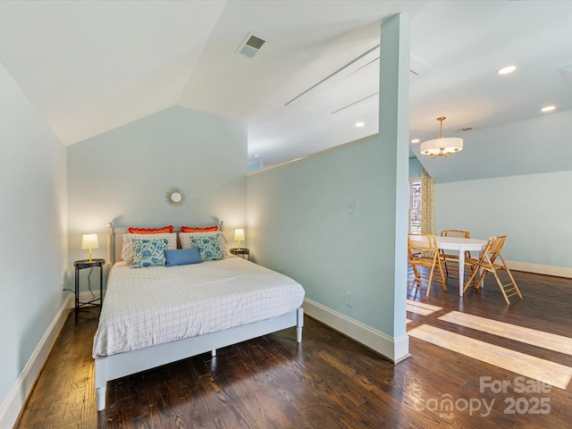 bedroom with baseboards, vaulted ceiling, wood finished floors, and visible vents