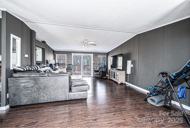 unfurnished living room featuring vaulted ceiling, ornamental molding, ceiling fan, dark wood-type flooring, and a textured ceiling