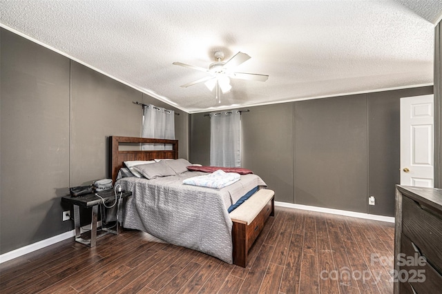 bedroom with dark hardwood / wood-style flooring, ceiling fan, ornamental molding, and a textured ceiling