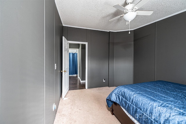 carpeted bedroom with ornamental molding, ceiling fan, and a textured ceiling