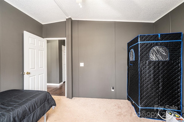 carpeted bedroom featuring ornamental molding and a textured ceiling