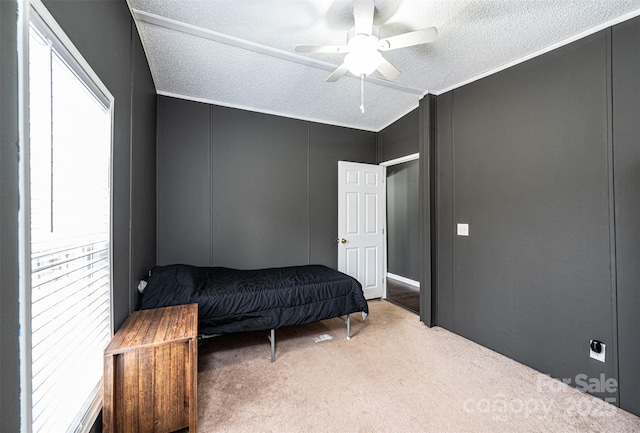 bedroom with multiple windows, light colored carpet, and a textured ceiling