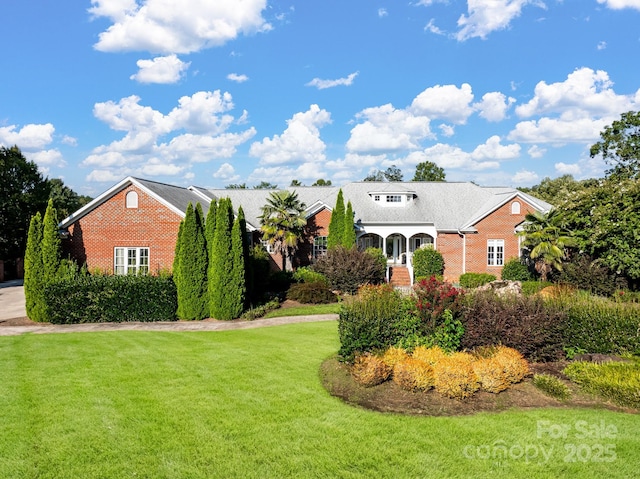 view of front of house featuring a front lawn and brick siding