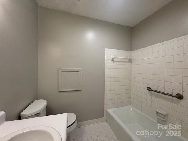 bathroom featuring sink, tile patterned flooring, a bathtub, and toilet