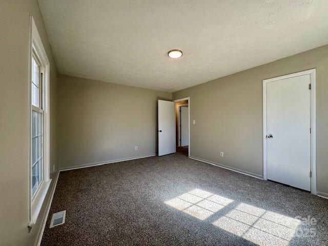 carpeted spare room featuring a textured ceiling