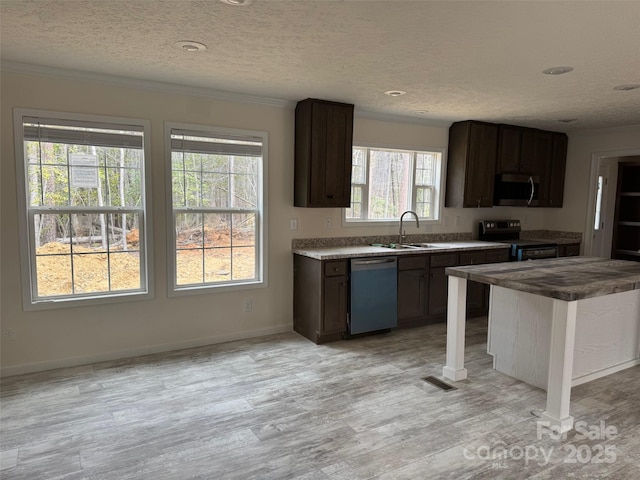 kitchen featuring crown molding, appliances with stainless steel finishes, and a sink